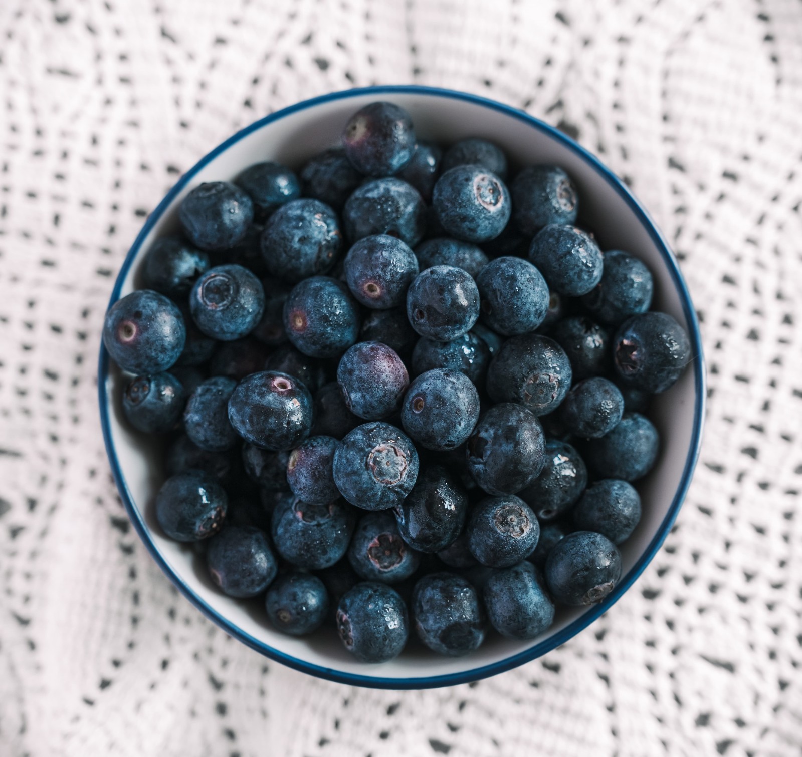 high-angle-shot-bowl-filled-with-blueberries-nice-white-tablecloth-table high-angle-shot-bowl-filled-with-blueberries-nice-white-tablecloth-table